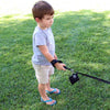 Small boy standing in shady grass holding leash with Tre Ponti Bag Dispenser in Black