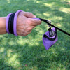 Hand holding leash with Tre Ponti Bag Dispenser in Lavender against grassy background
