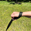 Human hand against grassy background showing Tre Ponti Long Run 16.4' Training Leash around the wrist